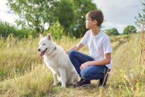 outdoor-portrait-of-boy-teenager-with-white-dog-2023-11-27-05-06-32-utc